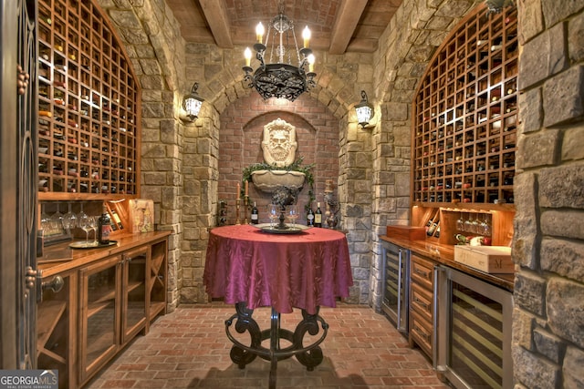 wine area featuring beverage cooler, an inviting chandelier, and beam ceiling