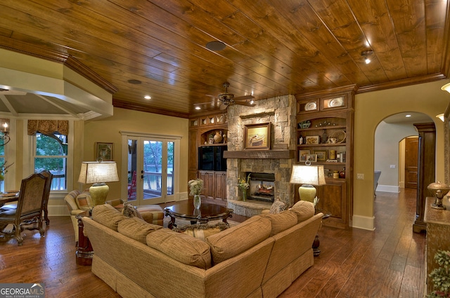 living room with a fireplace, a wealth of natural light, ceiling fan, and dark hardwood / wood-style floors