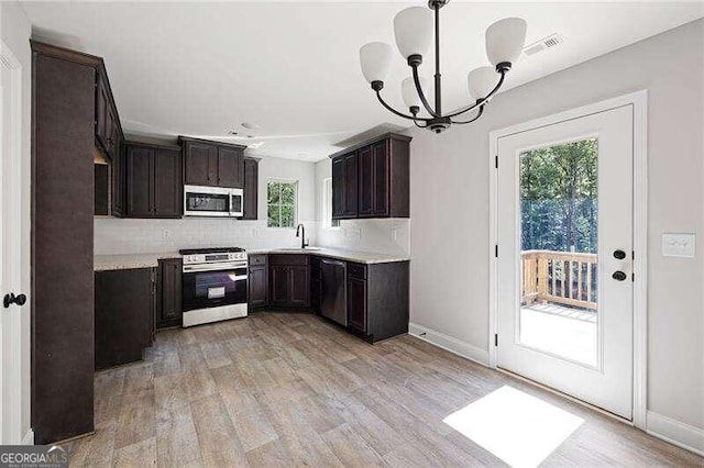 kitchen with backsplash, plenty of natural light, stainless steel appliances, and hanging light fixtures