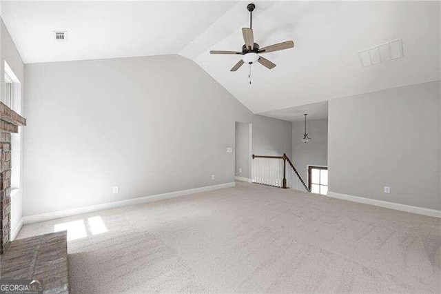 unfurnished living room with lofted ceiling, light carpet, ceiling fan, and a brick fireplace