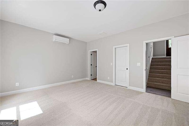 unfurnished bedroom with light carpet, a wall mounted air conditioner, and a closet