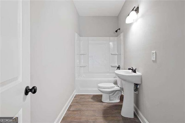 full bathroom with sink, wood-type flooring, tub / shower combination, and toilet