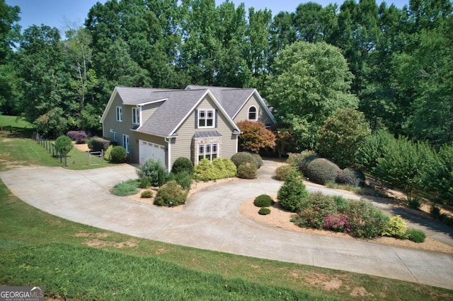 view of property with a garage and a front lawn