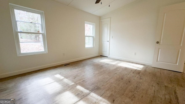 unfurnished room featuring ceiling fan, light hardwood / wood-style floors, a healthy amount of sunlight, and vaulted ceiling