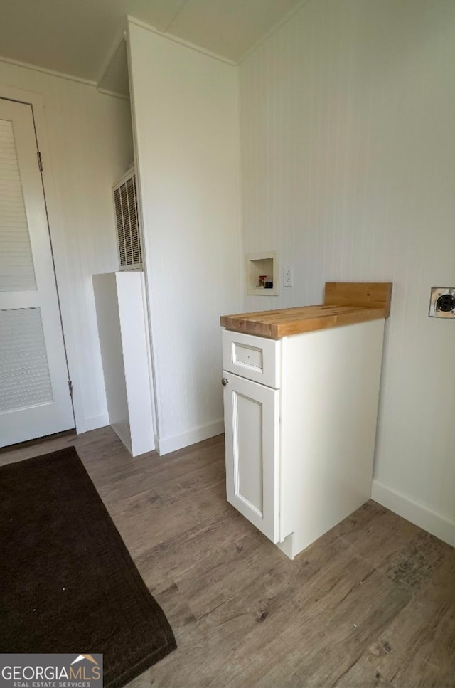 clothes washing area featuring dark wood-type flooring, cabinets, and hookup for a washing machine