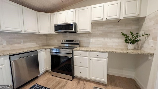 kitchen with backsplash, stainless steel appliances, white cabinets, and light wood-type flooring