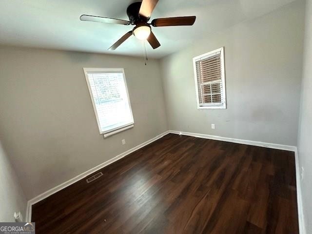 unfurnished room with ceiling fan and dark hardwood / wood-style flooring