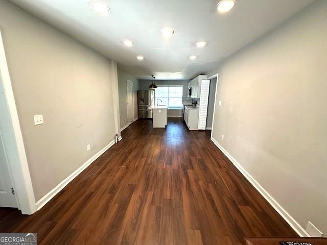 kitchen featuring dark hardwood / wood-style floors, stainless steel fridge, and white cabinetry