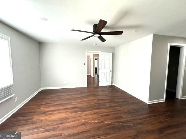 empty room featuring ceiling fan and dark hardwood / wood-style floors