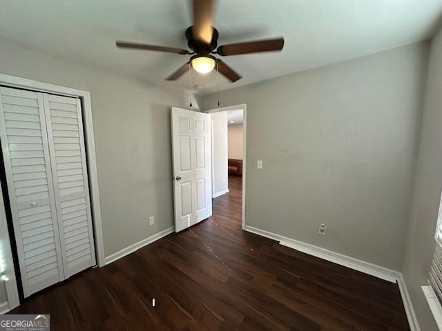 unfurnished bedroom with ceiling fan, a closet, and dark hardwood / wood-style floors