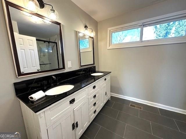 bathroom featuring tile patterned floors, vanity, and walk in shower