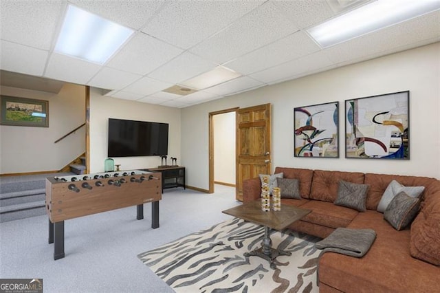 living room with a drop ceiling and light colored carpet