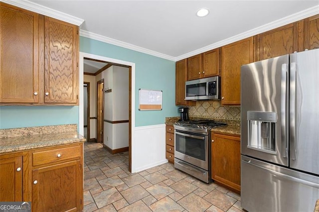 kitchen with light stone countertops, appliances with stainless steel finishes, backsplash, and ornamental molding