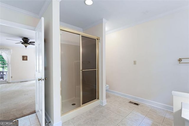 bathroom featuring crown molding, ceiling fan, a shower with shower door, and toilet