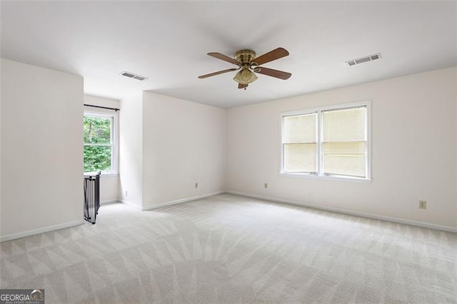 spare room featuring light colored carpet and ceiling fan