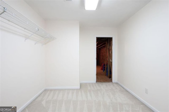 walk in closet featuring light carpet