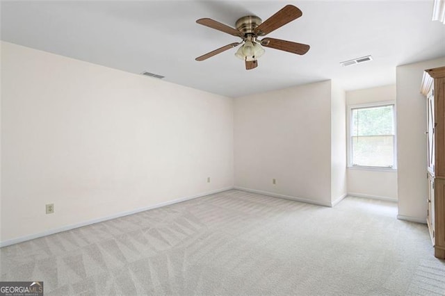 spare room featuring light colored carpet and ceiling fan