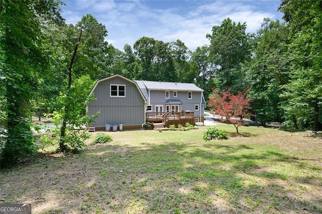 rear view of property featuring a yard and a deck