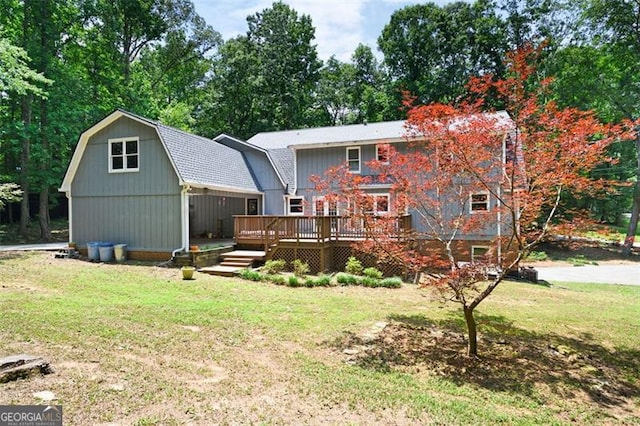 rear view of property featuring a deck and a yard