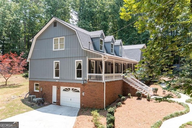 view of front facade with covered porch, central AC unit, and a garage