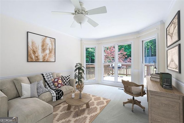 living room featuring ceiling fan, light colored carpet, and crown molding