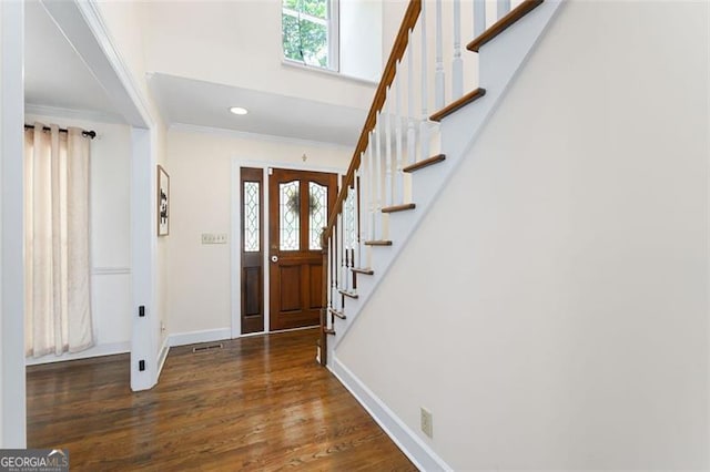 entrance foyer with dark hardwood / wood-style flooring, crown molding, and plenty of natural light