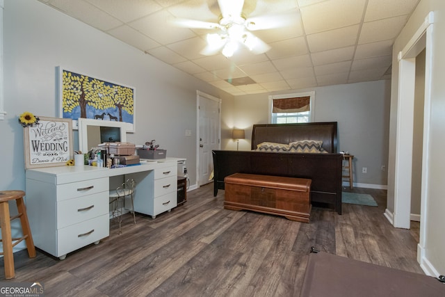 bedroom with a paneled ceiling, dark hardwood / wood-style floors, and ceiling fan