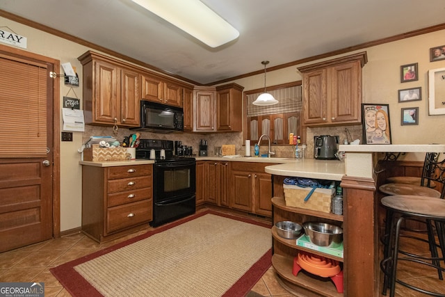 kitchen with sink, decorative light fixtures, a breakfast bar area, black appliances, and ornamental molding