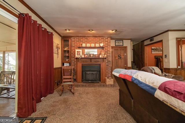 carpeted living room with ornamental molding, a fireplace, and wooden walls