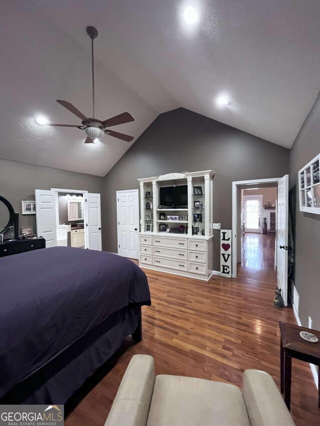 bedroom with hardwood / wood-style flooring, vaulted ceiling, and ceiling fan