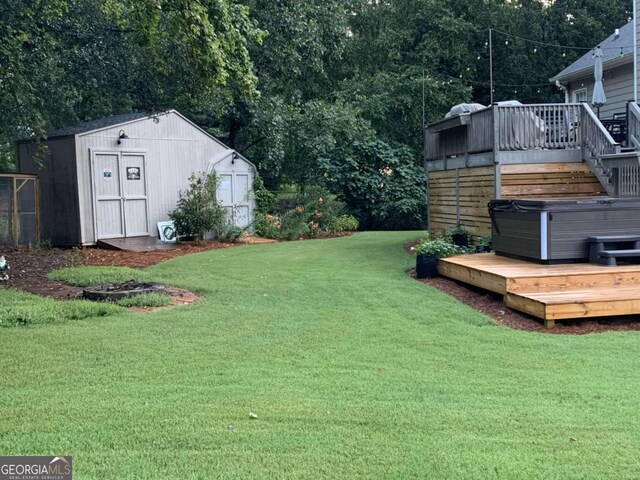 view of yard with a deck, a hot tub, and a storage shed