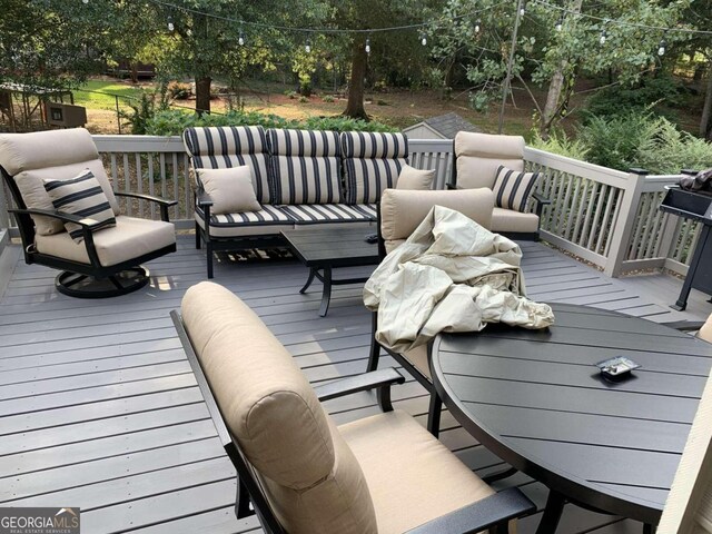 wooden terrace with an outdoor living space