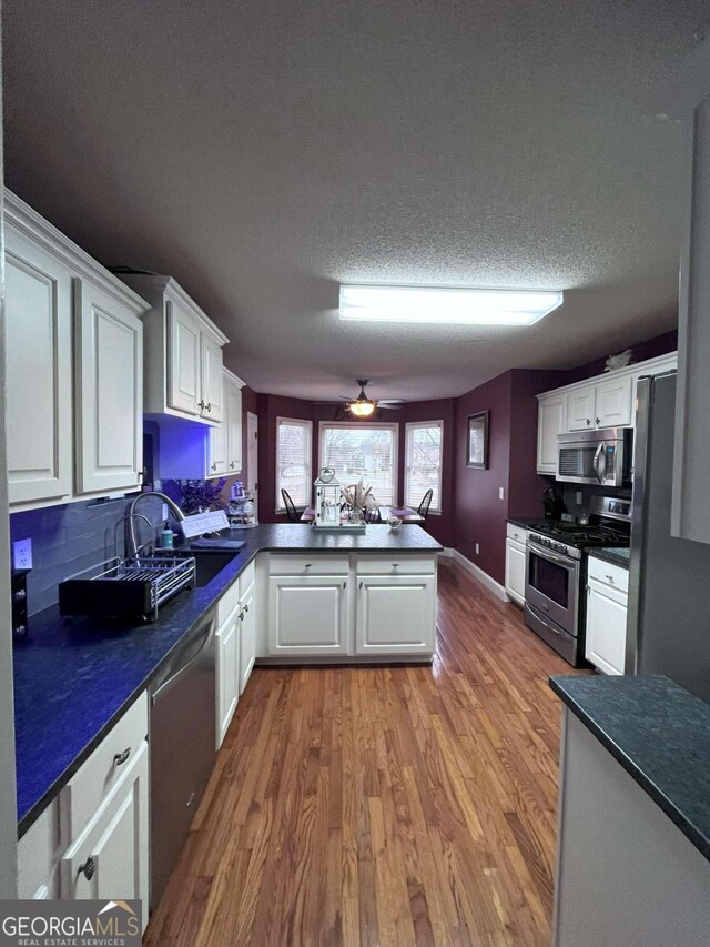 kitchen featuring white cabinets, appliances with stainless steel finishes, and kitchen peninsula