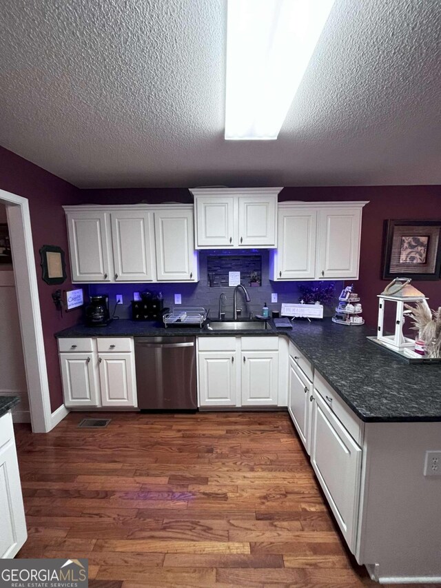 kitchen with stainless steel dishwasher, white cabinetry, and dark hardwood / wood-style floors