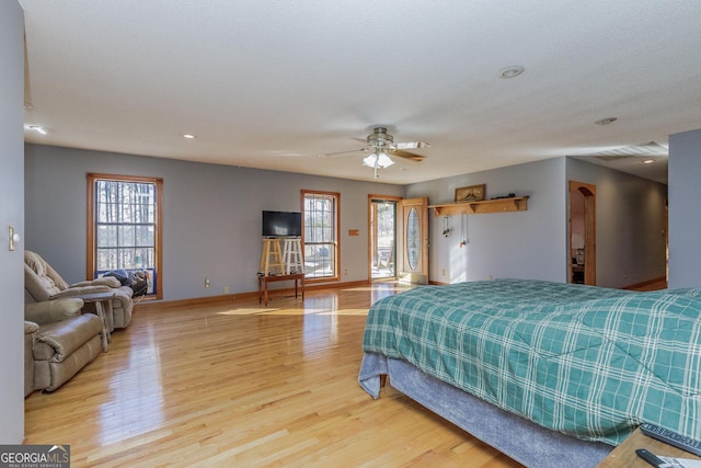 bedroom with multiple windows, ceiling fan, and light wood-type flooring