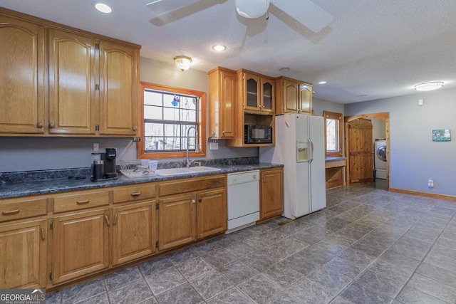 kitchen with a textured ceiling, white appliances, washer / clothes dryer, and plenty of natural light