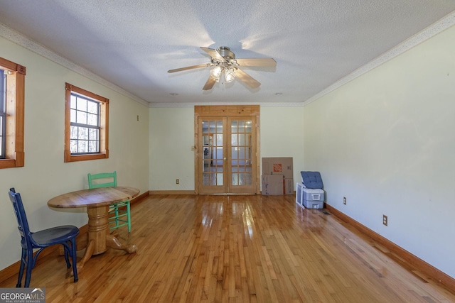 interior space with french doors, ceiling fan, ornamental molding, a textured ceiling, and light hardwood / wood-style floors