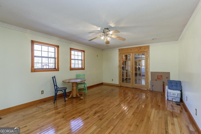 interior space with french doors, ornamental molding, a textured ceiling, ceiling fan, and light hardwood / wood-style flooring