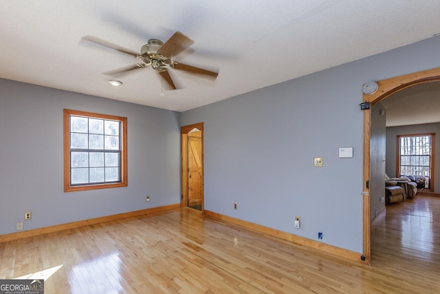 spare room featuring ceiling fan, a textured ceiling, a wealth of natural light, and light hardwood / wood-style flooring