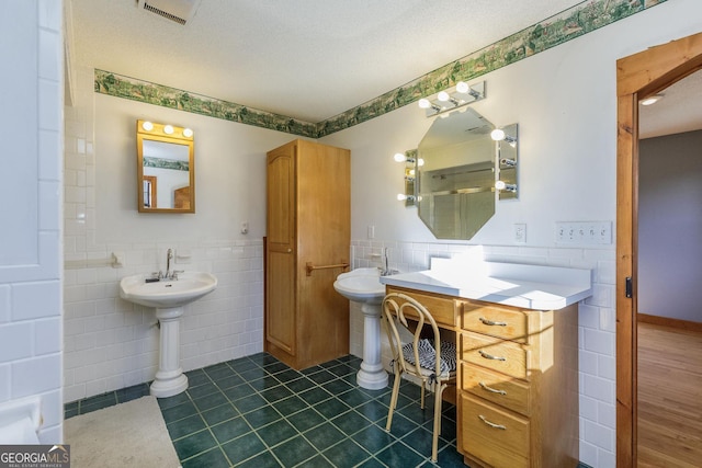 bathroom with tile patterned floors, tile walls, and a textured ceiling