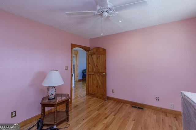 interior space featuring ceiling fan, light hardwood / wood-style flooring, and a textured ceiling