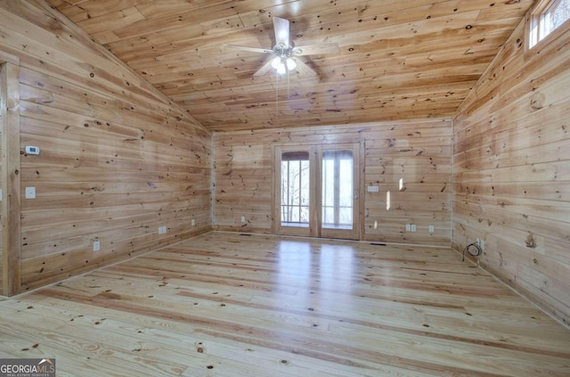 unfurnished room with wood walls, vaulted ceiling, wood ceiling, and french doors