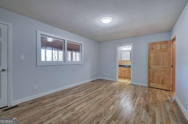 spare room featuring hardwood / wood-style flooring and a textured ceiling