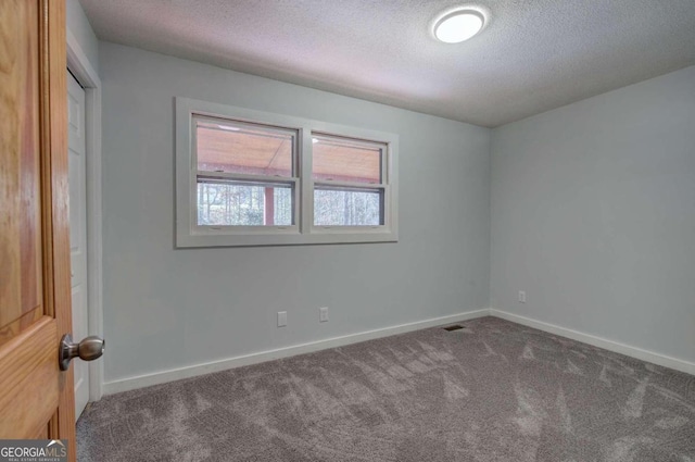 carpeted spare room with a textured ceiling