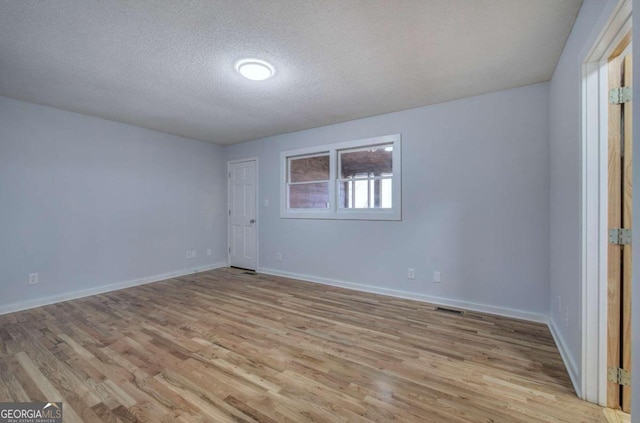 unfurnished bedroom with light wood-type flooring and a textured ceiling