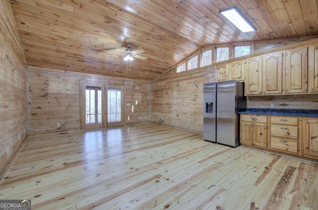 kitchen with wood walls, stainless steel fridge, light hardwood / wood-style flooring, and french doors