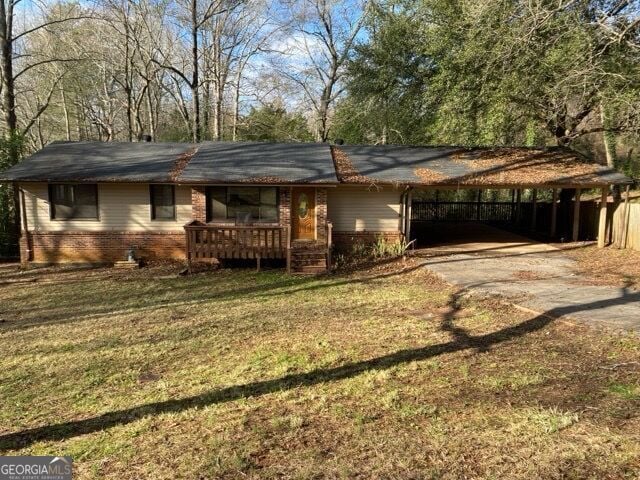 rear view of house featuring a yard and a carport