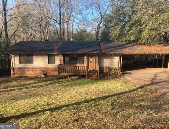 view of front of home with a carport and a front yard