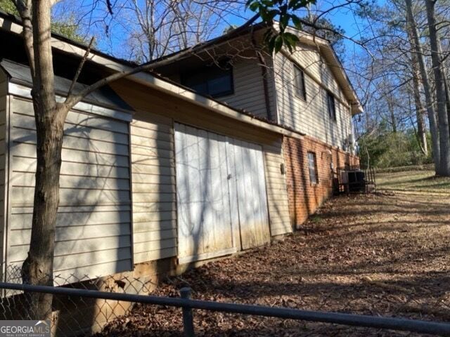 view of side of home with a garage and central AC unit