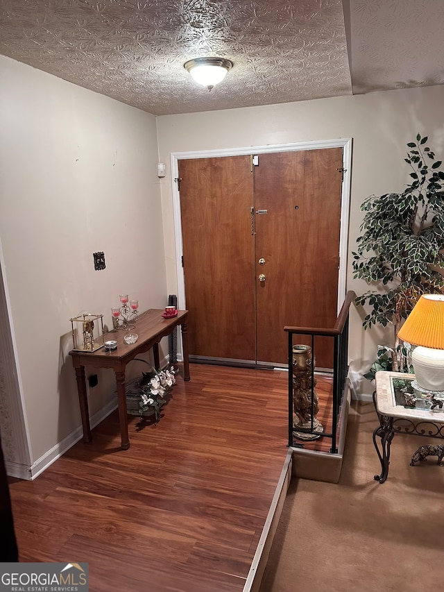 entryway featuring dark hardwood / wood-style flooring and a textured ceiling